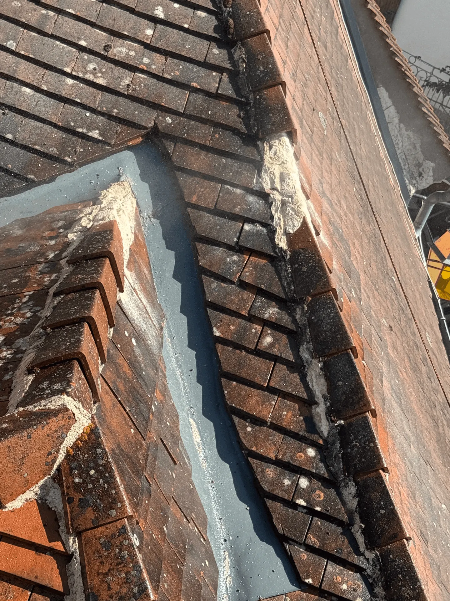 Raccord métallique entre une toiture en tuiles et un mur